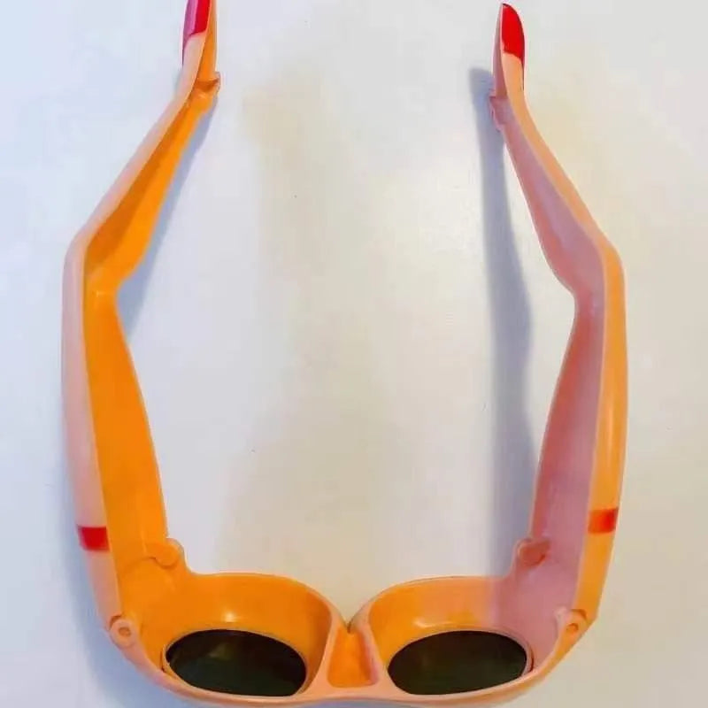 Orange novelty sunglasses with a unique leg hip personality silhouette on a solid background.