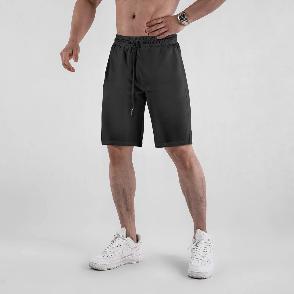 Man wearing loose black quick-dry polyester fitness shorts with an elastic waistband.