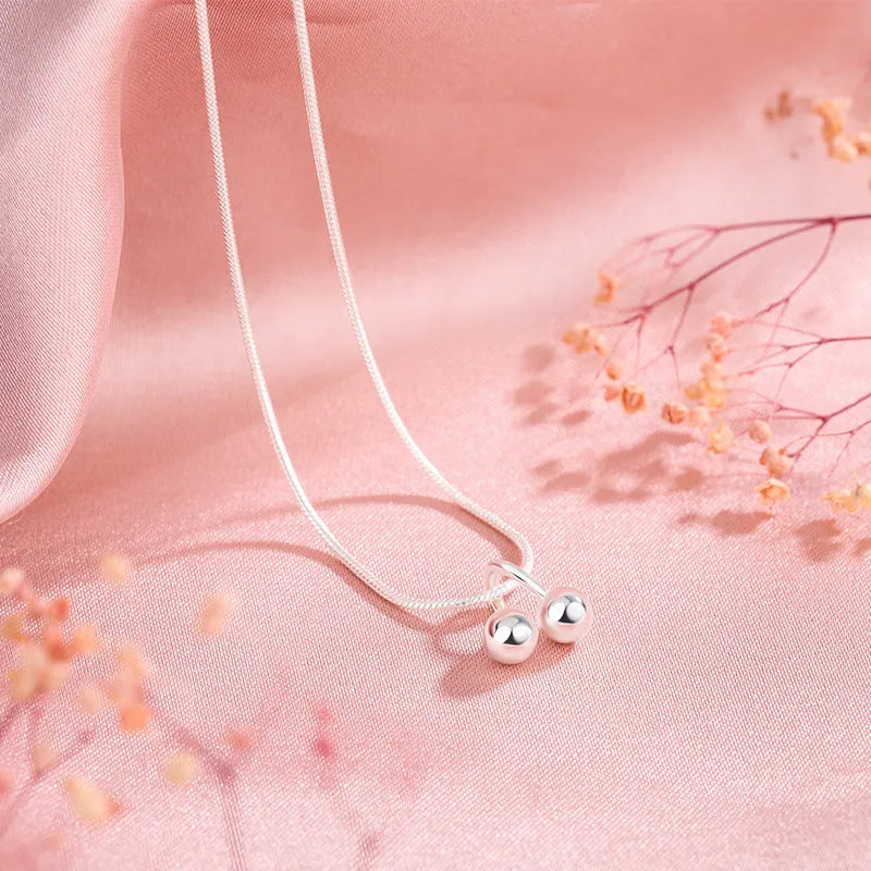 925 silver cherry pendant necklace with an adjustable snake bones chain on a white background.
