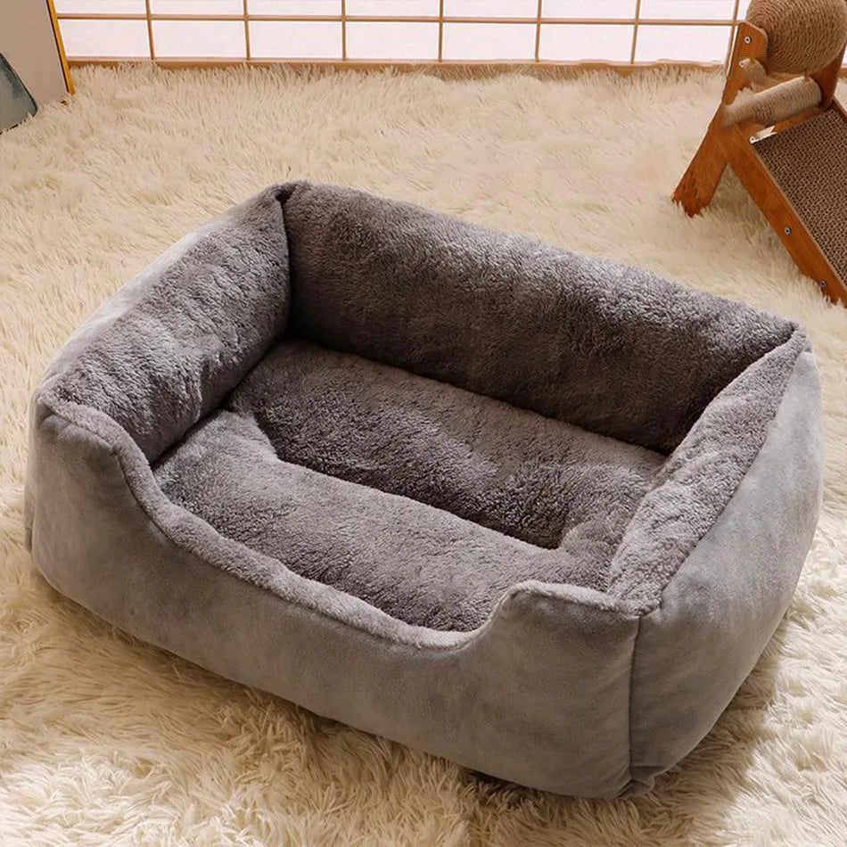 Soft short plush cat bed in grey, shown in a medium size for scale with a cat.