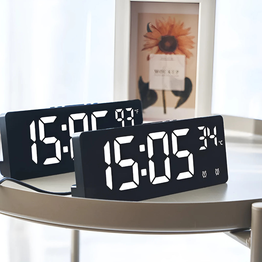 Electronic alarm clock with large LED screen showing time and temperature, in acrylic casing.