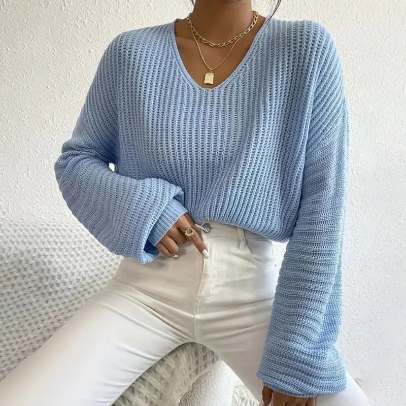 Woman wearing a solid colour long sleeve loose fit casual polyester pullover.