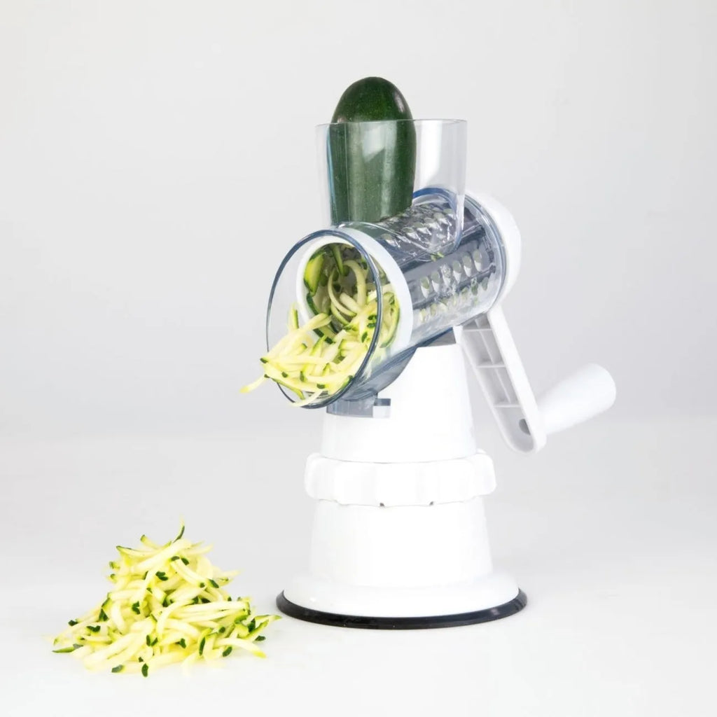 White manual vegetable slicer, grater, and chopper with three stainless steel blades and suction feet.