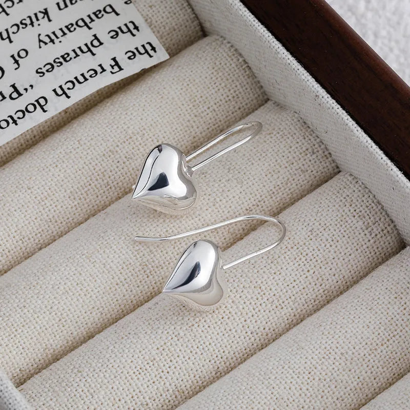 3D glossy silver heart-shaped earrings with Korean style design on a white background