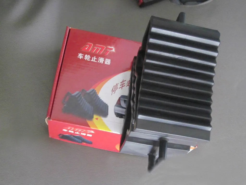 A pair of black triangular car wheel chocks for anti-slip parking safety.