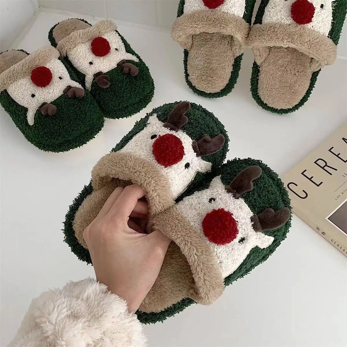 A pair of women's pink cotton slippers with a Christmas deer pattern and a white non-slip PVC sole.