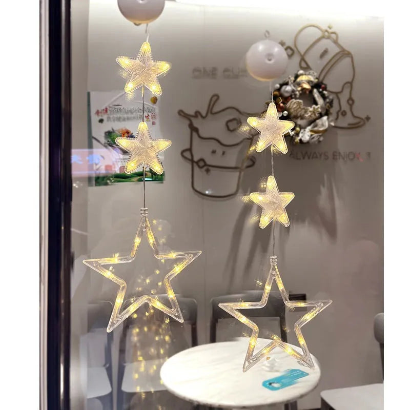 Three Christmas LED light ornaments with suction cups hanging on window
