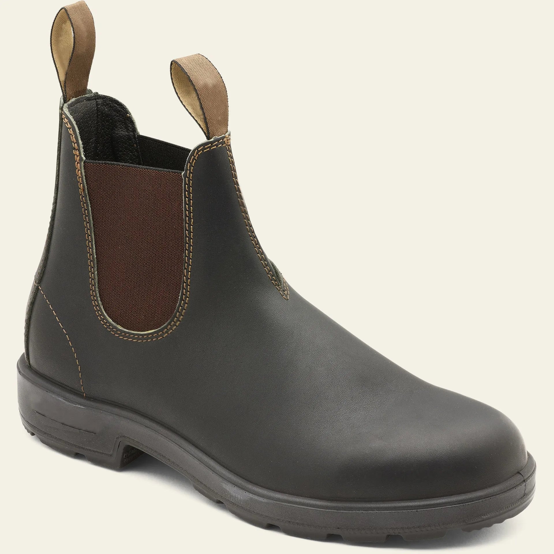 Vintage brown unisex Chelsea boots with round toe and low horseshoe heel on a wooden floor.