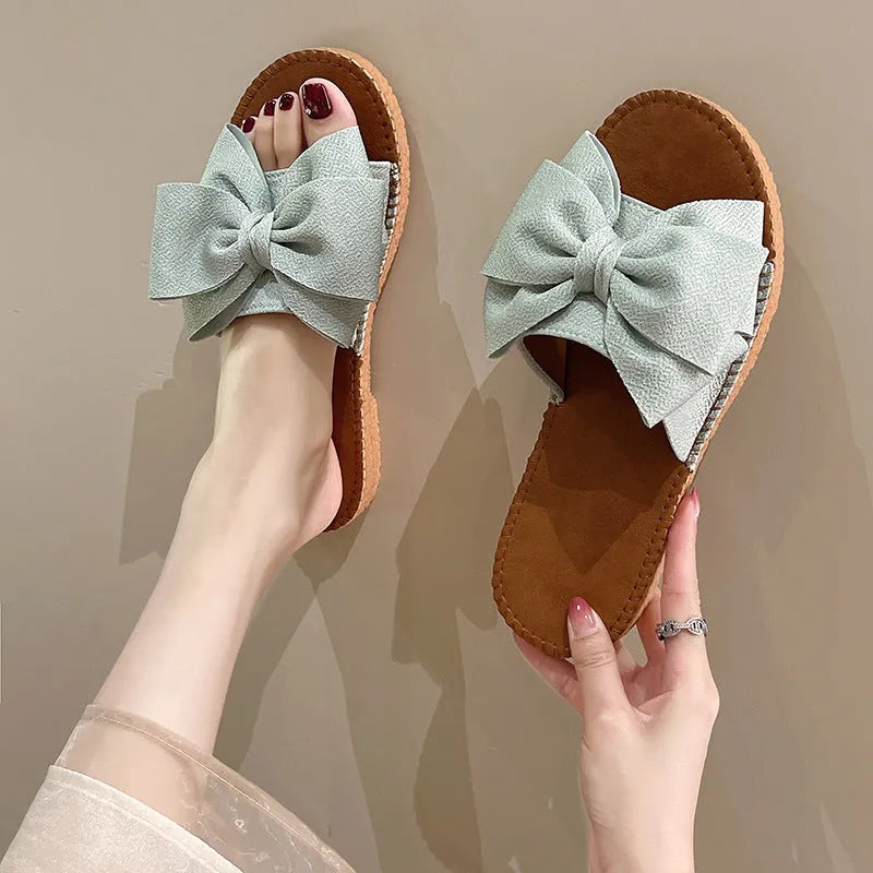 Women's beige suede sandals with bow detail and flat rubber soles