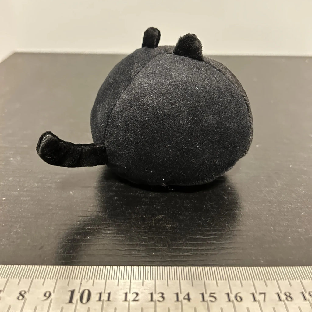 Fluffy black cat plush toy stuffed animal pillow cushion on a neutral background