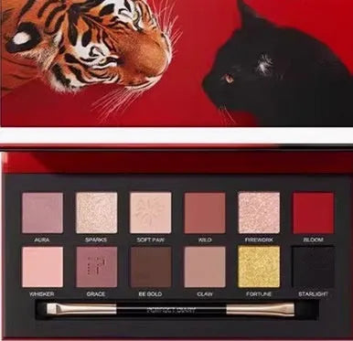 Open palette showing twelve pressed powder eyeshadow pans with animal-themed colour names.