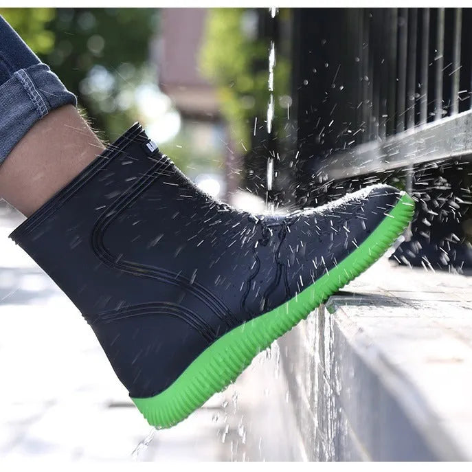 Men's mid-top PVC rain boots in black with green detailing, tassel decoration, and non-slip sole