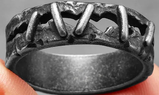 A dark-coloured stainless steel double ring with a punk stitching design pattern.