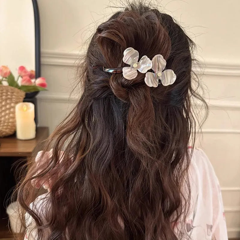 Retro flower petal bobby pin hair accessory in acrylic, shown on a background.