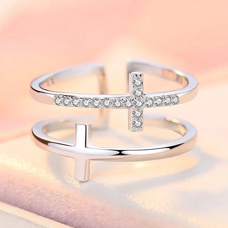 Adjustable double cross geometric ring with zircon stones in a white gold colour finish.