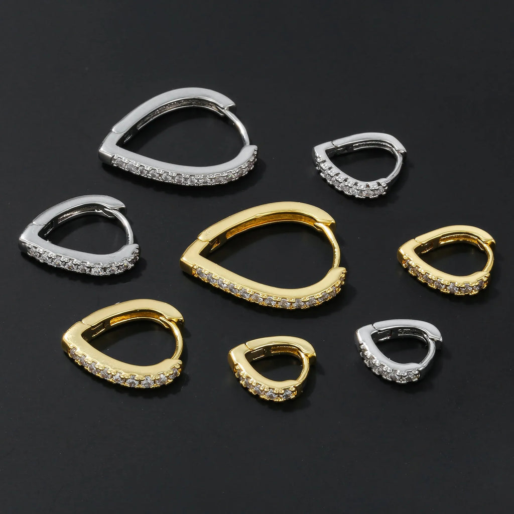 Geometric gold-coloured heart-shaped ear clip on a white background.
