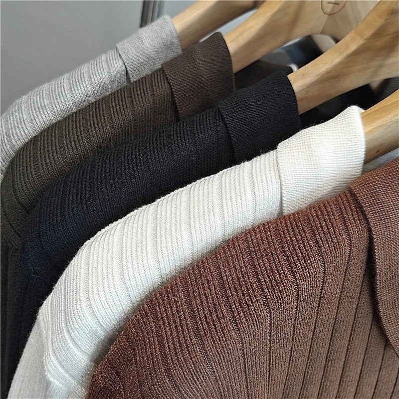 Man wearing a loose striped knitted sweater with a lapel collar in light grey.