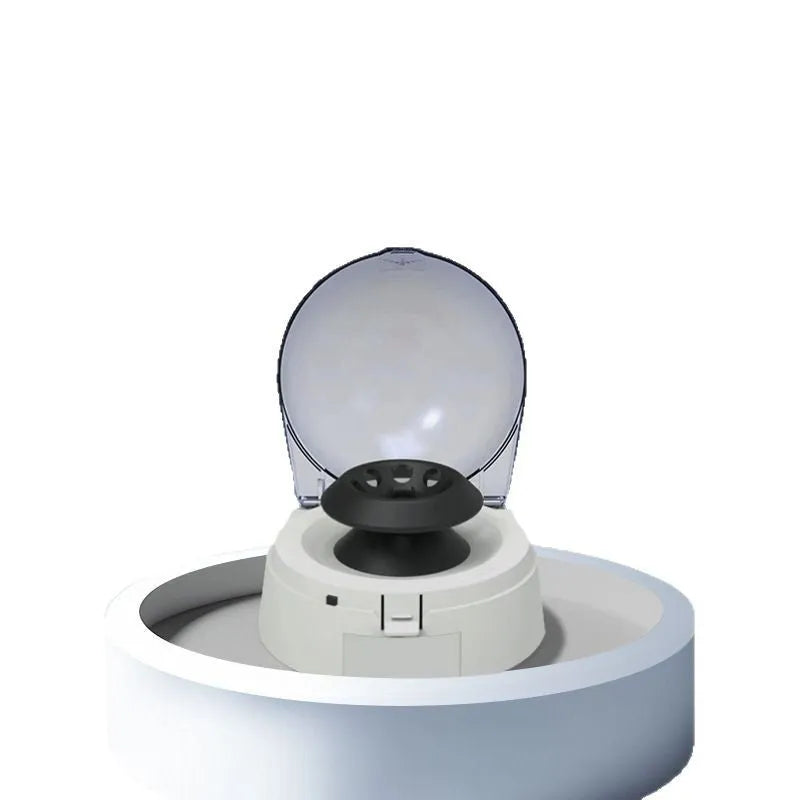 Small white mini laboratory centrifuge unit on a benchtop.
