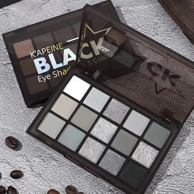 Open 15-pan eyeshadow palette showing matte and shimmer shades in browns, greys, blacks, and blues.