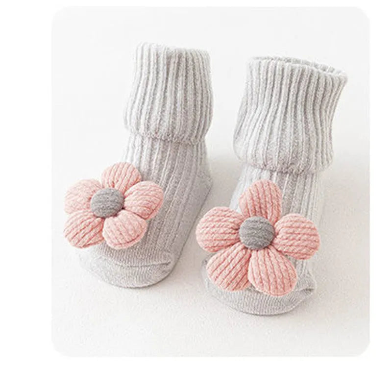 Cotton baby floor socks in a pink bow pattern, shown on an infant's feet.