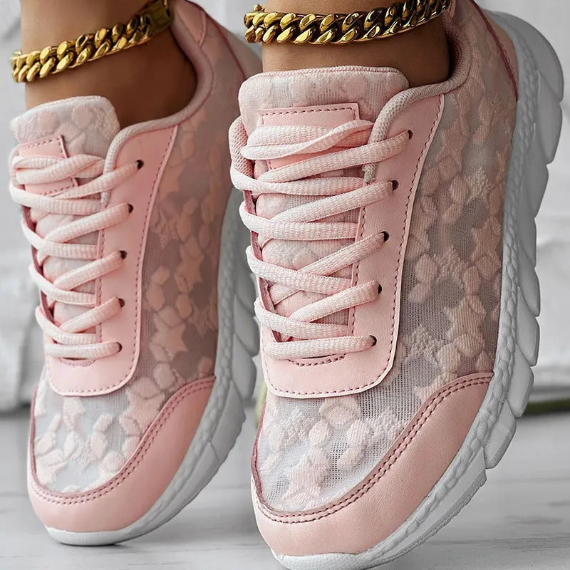Women's white canvas running shoes with flat heel and round toe on a plain background.