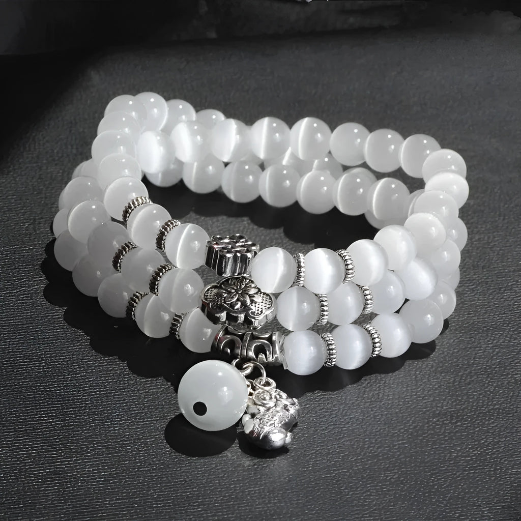 Women's opal bracelet with a Cat Eye charm, shown in one of six colours, wound three times around a wrist.