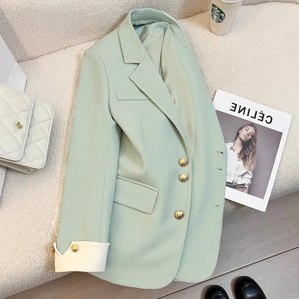 Milky white loose-fit mid-length women's coat with long sleeves and pockets on a hanger.