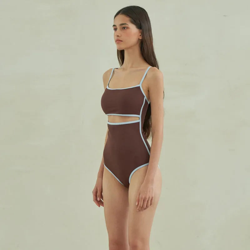 Brown women's one-piece swimsuit with a triangle pattern top on a hanger.