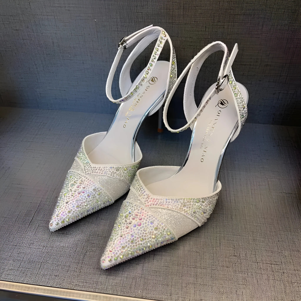 Women's black and silver hollow high heels with a red sole and pointed stiletto toe.