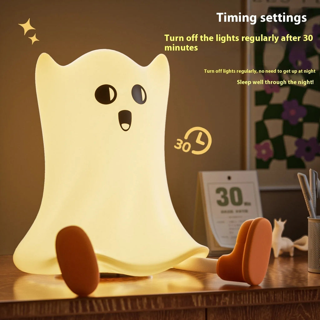 Cartoon ghost-shaped silicone bedside lamp with touch control, soft yellow glow on a bedside table