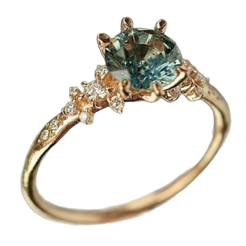 Gold plated claw ring with a central zircon stone and geometric square pattern.