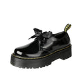 Women's black leather flat shoes with thick soles, cross straps, ribbons, and laced closure.