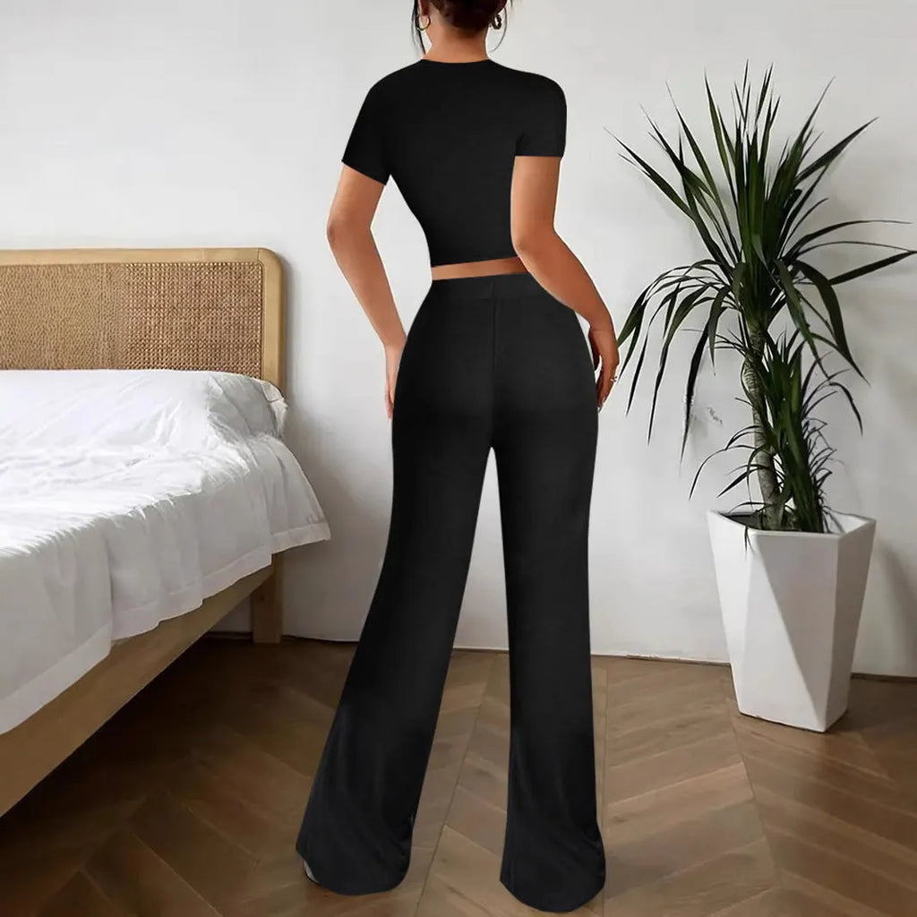 Black high-waist trousers and matching short-sleeve t-shirt set on a hanger.