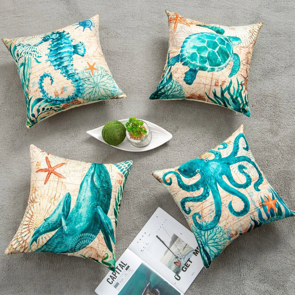 Square linen cushion cover with a detailed blue and green sea turtle print, shown on a grey sofa.