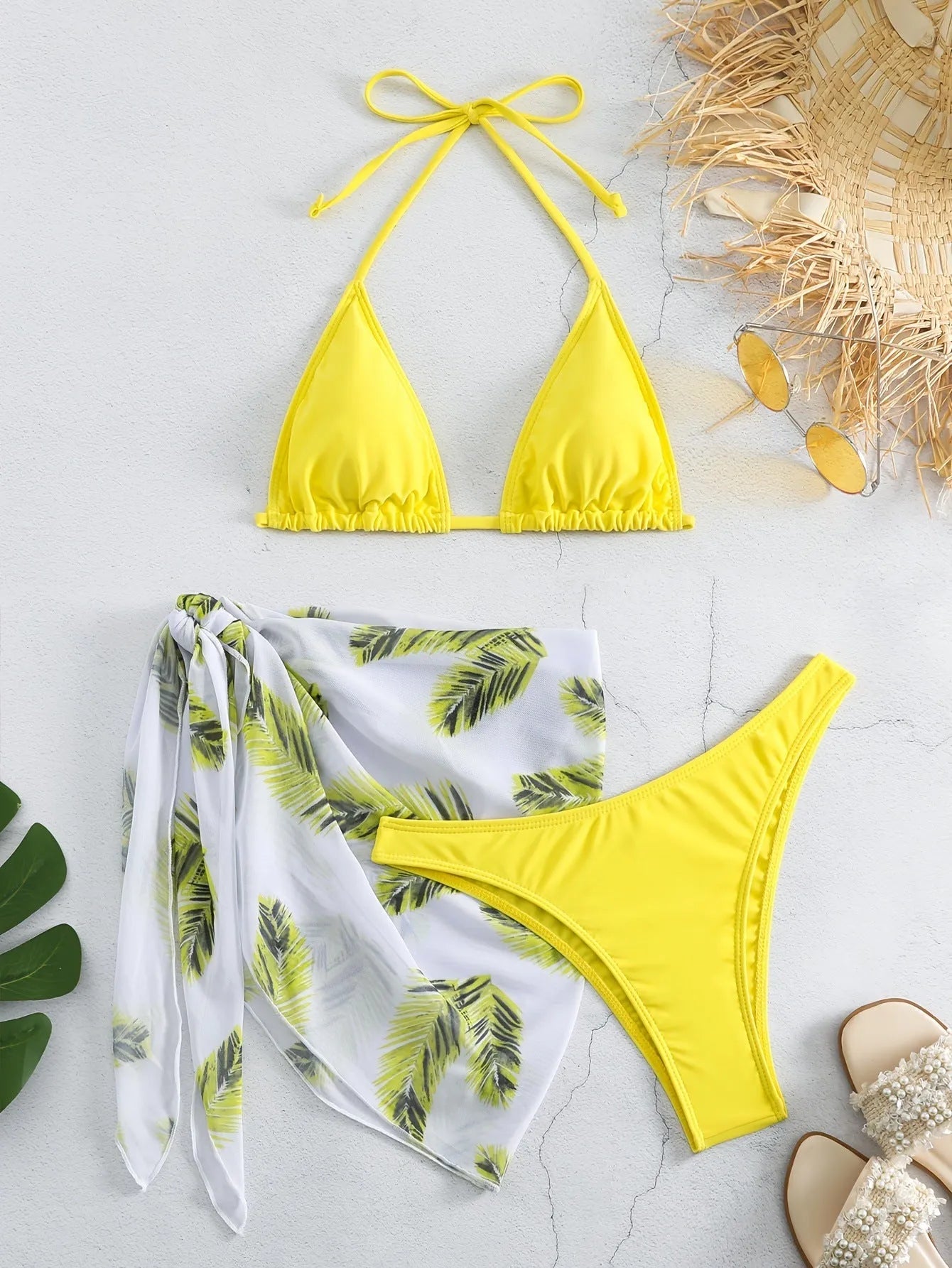 Women's orange three-piece bikini swimsuit set with a matching gauze skirt on a mannequin