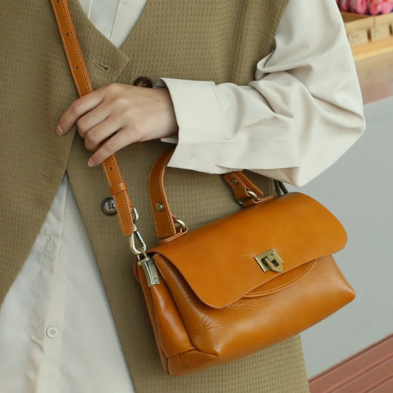 Dark brown women's saddleback leather handbag with double straps and an open front pocket.