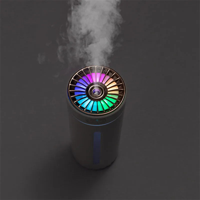 Black portable USB humidifier with colourful lights on a car cup holder.