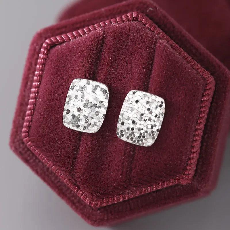 Pair of crushed ice square 925 silver stud earrings with white gold colour finish and geometric carved surface