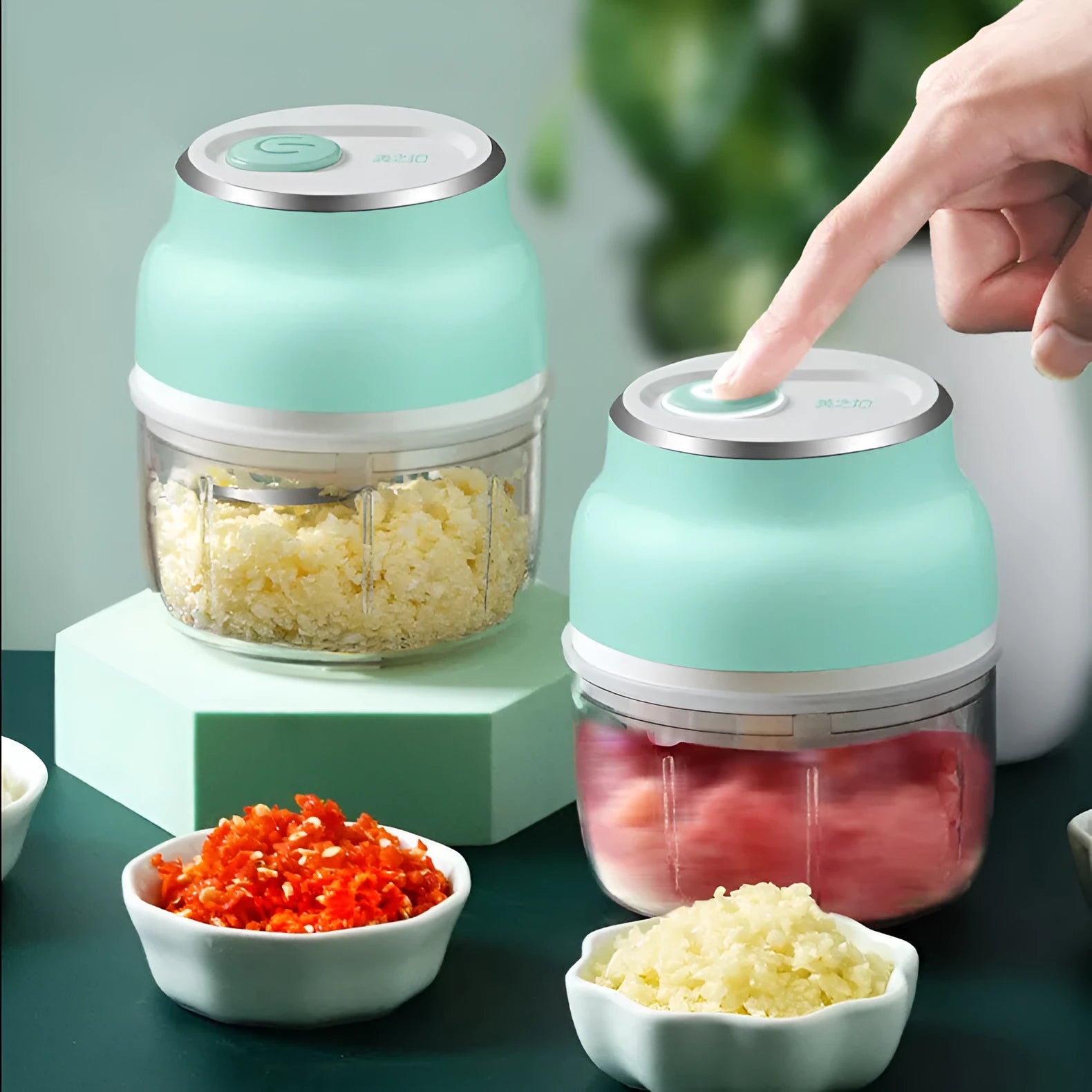 Electric food chopper with transparent cup and stainless steel blade on kitchen counter