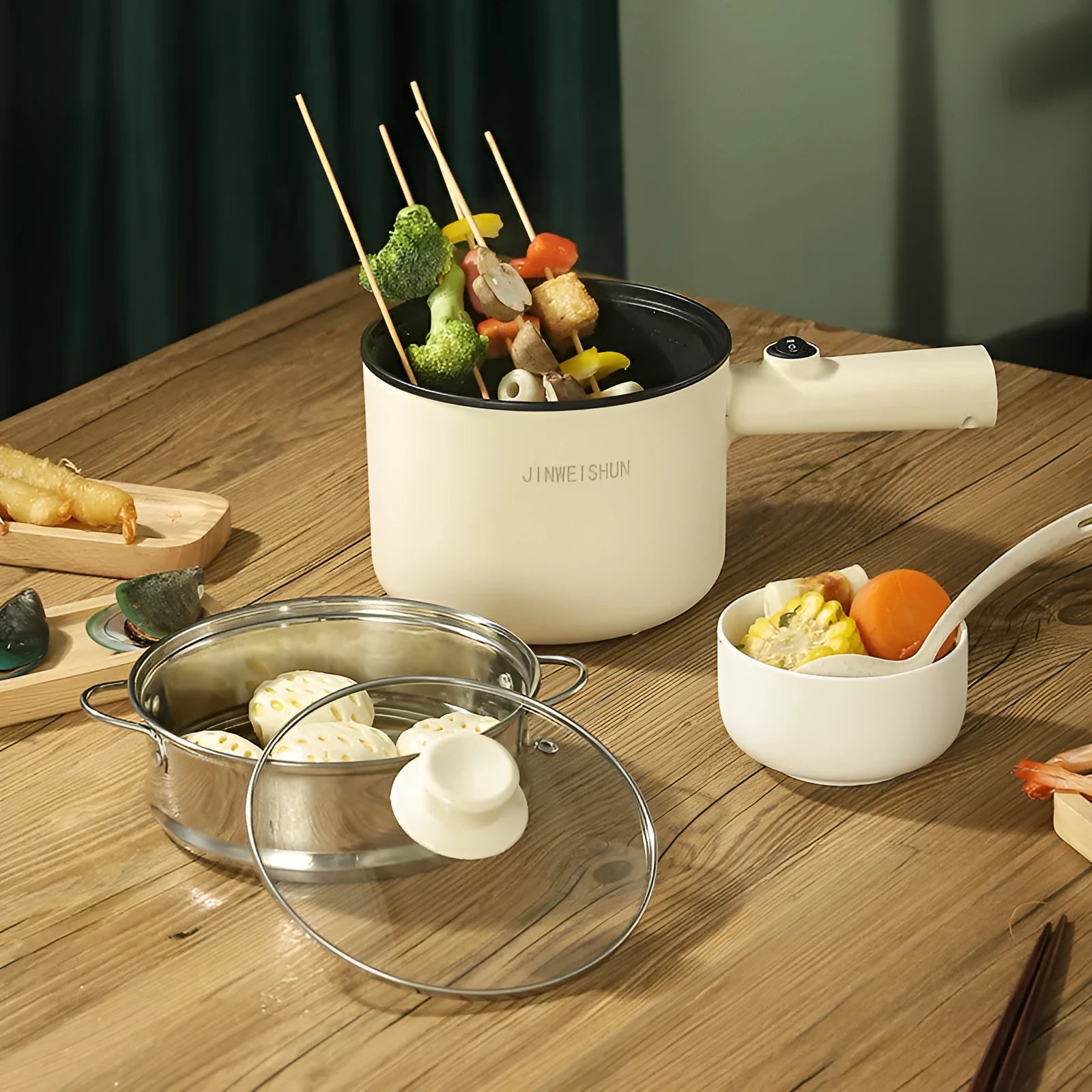 Mini electric hot pot appliance in stainless steel with non-stick coating and included cooking accessories