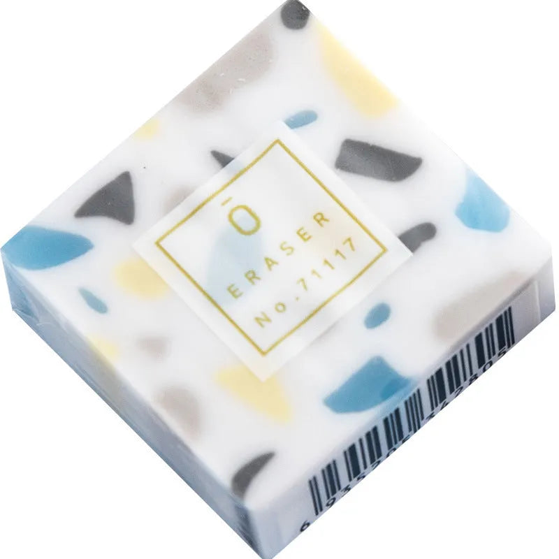 Small white PVC eraser for art drawing on a blue background.