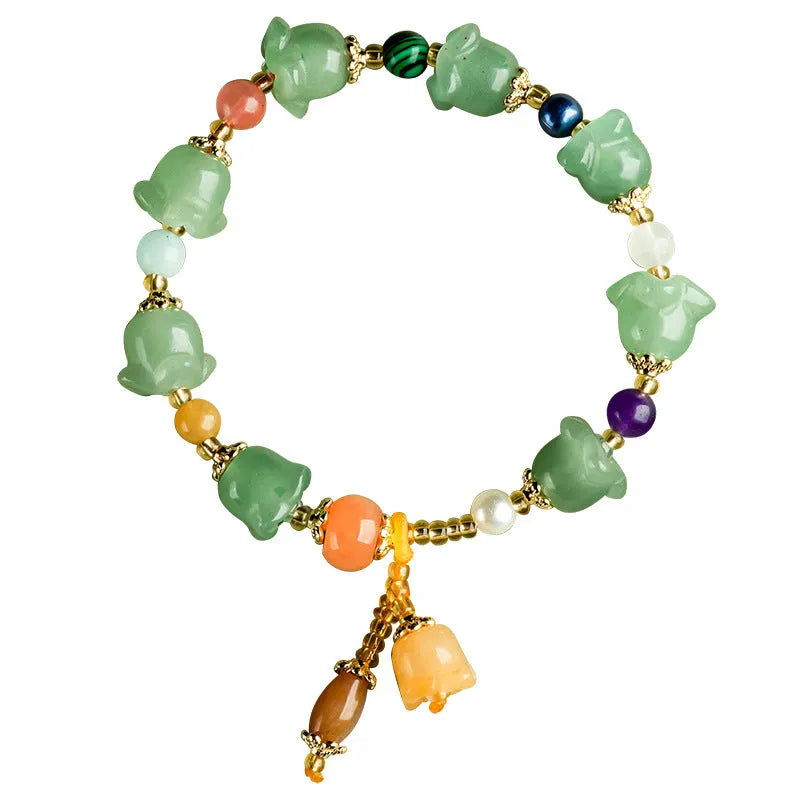 Close-up of a carved orchid bead jade bracelet in aventurine orchid colour on a wrist.